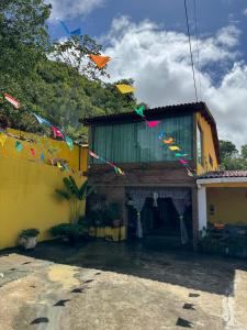 a house with colorful kites flying in the air at Casa amarela Serra negra ! in Bezerros