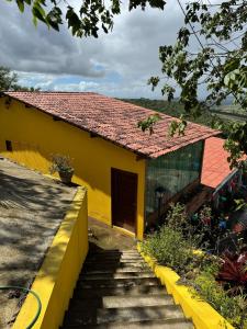 a yellow house with a staircase leading up to it at Casa amarela Serra negra ! in Bezerros +1 photo