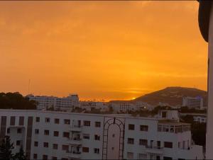 a building with the sunset in the background at Beach apartment Agadir in Agadir