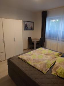 a bedroom with a bed and a table with a chair at Ferienwohnung Ella in Gries