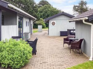 a patio with chairs and a table and a building at 8 person holiday home in Nakskov in Nakskov