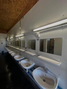 una fila di lavandini in un bagno pubblico con specchi di Tinyhome Spielberg -Container Lodge a Flatschach