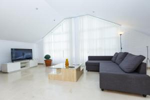 a living room with a couch and a tv at Pizarra Villa Planetcostadorada in Tarragona