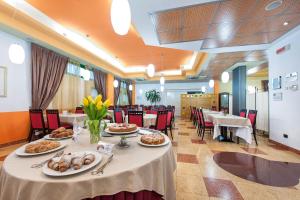 una mesa larga con comida en un restaurante en West Point Airport Hotel en Dossobuono