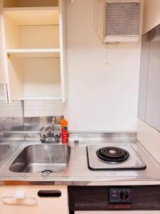 札幌市にあるNakajima502 1stop to Susukino, quiet location next to Nakajima Park, can accommodate 2 peopleのシンクとコンロのある小さなキッチン
