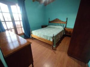 a bedroom with a bed in a room with blue walls at Alojamiento Corral de Piedras in Malargüe