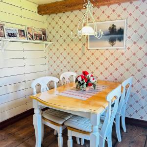 a dining room table with chairs and a vase of flowers at Visthuset, historical cottage at Långnäs Manor in Långnäs +20 photos