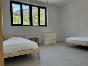 Un dormitorio con dos camas y una ventana. en Dinard centre, en Dinard