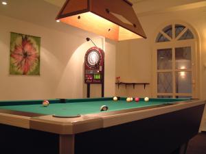 une chambre avec un billard et une horloge dans l'établissement Villa Székely, à Leányfalu