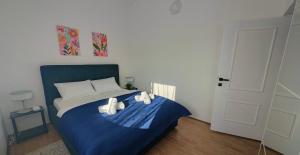 a bedroom with a blue bed with towels on it at Apartman Lunna in Vrsi