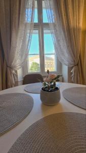 a white table with a window and a vase on it at Fountain Residence in Sopron