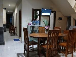 a dining room with a wooden table and chairs at Obama House Ubud in Ubud