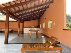 a wooden bench in a room with a table at Sítio do Juju-15km Aeroporto de Confins in Pedro Leopoldo