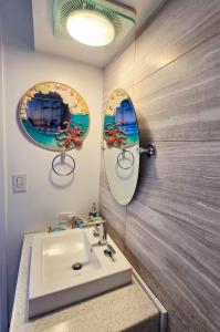 baño con lavabo y tabla de surf en la pared en Ocean & Marina View Suite, en Honolulu 19 fotos más