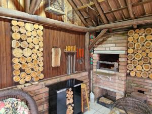 a large room with a fireplace and a pile of logs at Cabana do Morro in Genuino Sampaio