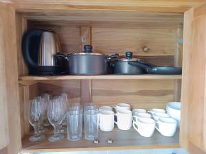 a wooden cabinet with dishes and glasses and pots and pans at Playa de Canoa in Canoa +15 photos