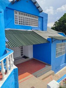 a blue house with white windows and a balcony at Casa en Tocaima Cundinamarca in Tocaima