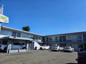 a hotel with cars parked in a parking lot at Palms motel in Oakland