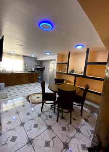 a dining room with a table and chairs and blue lights at Adem s1 in 'Aïn el Turk