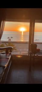 a room with a view of the ocean and the sunset at BEACHFRONT VUE SUR MER APPARt in Dar Merah Deriba +14 photos