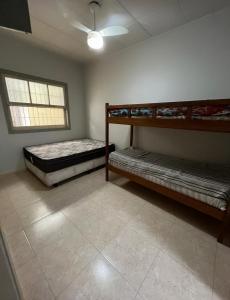 a room with two bunk beds and a window at Casa grande e arejada ao lado da praia! in Itanhaém
