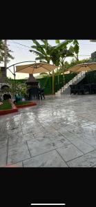 a patio with benches and tables with umbrellas at Azure Waves in Vlorë