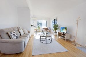 una sala de estar con un sofá y una mesa en Seaside Escape, en Lakes Entrance