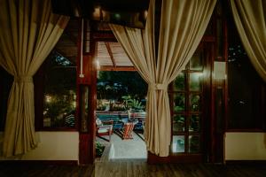 an open door to a patio with curtains at Villa Lu Amazon Ecolodge in Tarapoto
