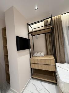 a small bedroom with a bunk bed and a tv at Azure Waves in Vlorë