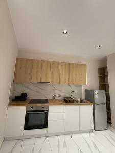 a kitchen with white cabinets and a refrigerator at Azure Waves in Vlorë