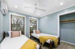 Dos camas en una habitación con paredes y ventanas azules. en Wine Stop Quarters Pool, Tour, Pickup Wineries, en Nulkaba 18 fotos más