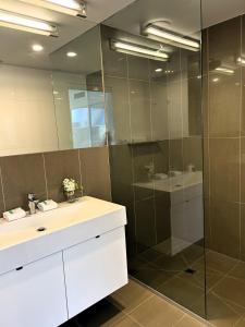 a bathroom with a sink and a glass shower at PROMENADE TOWERS 2 Bedroom Apartment with City Views on the Geelong Waterfront - 506 in Geelong