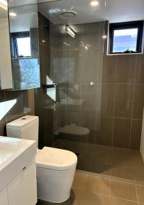 a bathroom with a toilet and a glass shower at PROMENADE TOWERS 2 Bedroom Apartment with City Views on the Geelong Waterfront - 506 in Geelong +15 photos