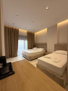 a hotel room with two beds and a laptop at Azure Waves in Vlorë