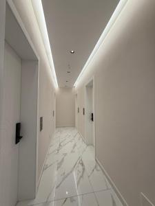 a hallway with white walls and white tile floors at Azure Waves in Vlorë