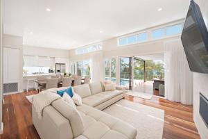 a living room with a white couch and a kitchen at The Lookout in Corlette