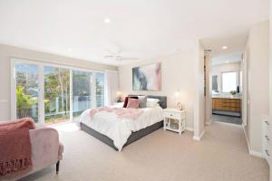 a bedroom with a bed and a large window at The Lookout in Corlette +24 photos