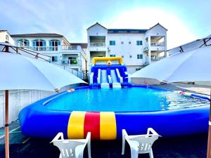 a pool with a colorful inflatable raft and two umbrellas at Taean Sharon Pension in Taean