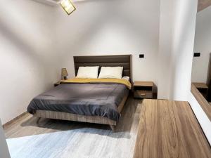 una camera da letto con un letto in una stanza bianca di حي الواحات a El Aouina Station