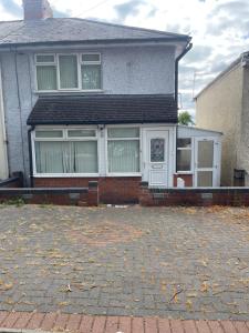 a house with a brick driveway in front of it at Cleeve Road House in Birmingham