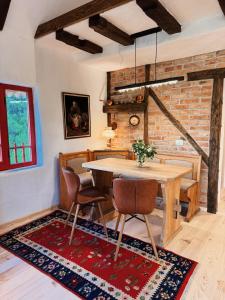 a dining room with a wooden table and chairs at Inside, The Village- The Brick Loft in Tunari