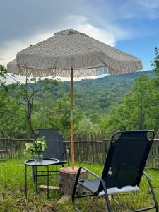 two chairs and a table with an umbrella at Inside, The Village- The Brick Loft in Tunari