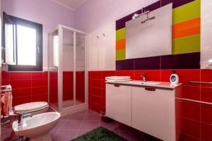 a colorful bathroom with a sink and a toilet at B&B Solesun in Trapani