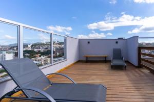 a balcony with chairs and a table on a building at Loft novo e aconchegante perto do centro histórico in São João del Rei