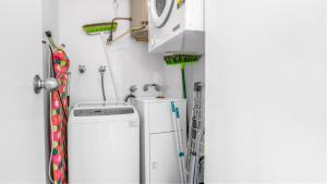 eine Waschküche mit Waschmaschine in der Unterkunft Beachpoint 402 in Forster