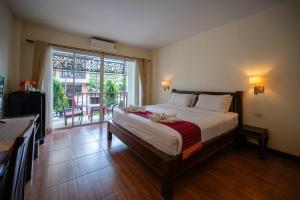 Un dormitorio con una cama grande y una ventana grande. en Riverside House Hotel, en Chiang Mai