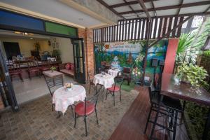 un restaurante con 2 mesas y sillas en una habitación en Riverside House Hotel, en Chiang Mai