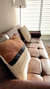 拉塞雷纳Brisa Serena Suites Dpto 2D 2B Full Equipado的棕色皮沙发,配有枕头