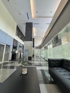 a lobby with a black couch and a potted plant at Scientia Residences Gading Serpong by Taslim in Serpong