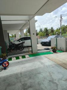 a car parked in a garage with a motorcycle parked at Homestay Apamanis, Alor Setar in Kepala Batas